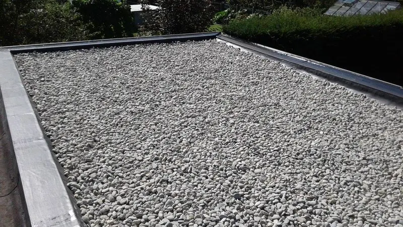 Renovatie plat dak garage te Melle: ballastlaag met grind op het dak