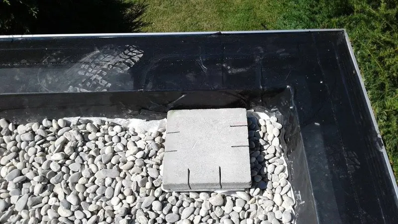 Renovatie plat dak garage te Melle: dakafvoer (tapbuis)